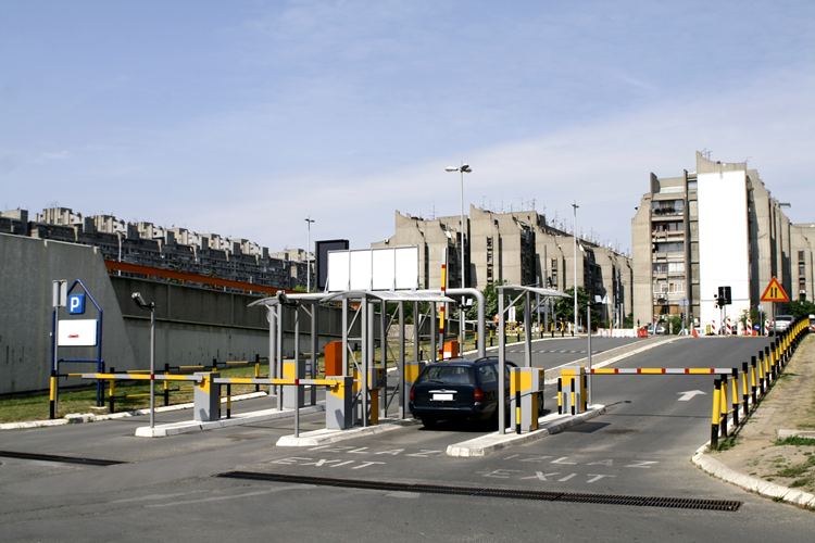 A visitor in a vehicle arriving for check-in at a gated facility parking entrance.